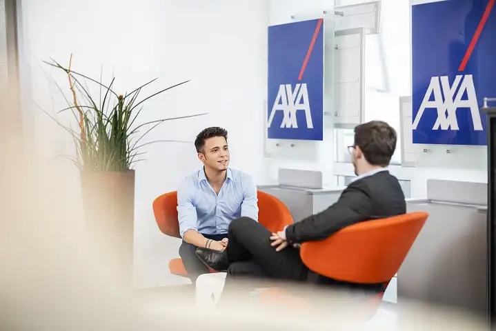 Karriere im Versicherungsvertrieb bei AXA: Beratungsgespräch zwischen Kundenberater und Kollege im modernen Agentur-Büro